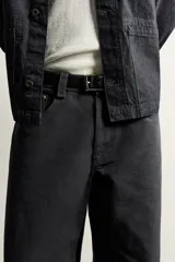 Jeans relaxed fit de corte recto y tiro medio, color negro, confeccionados en denim de algodón rígido con diseño de cinco bolsillos y cierre frontal de cremallera y botón.