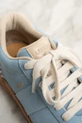 Zapatilla de gamuza celeste con cordones blancos, suela marrón y detalle de la marca "Lemon" en el lateral.