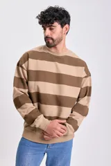 Buzo deportivo de cuello redondo, color beige con rayas horizontales marrones. Tiene mangas largas y puños y dobladillo acanalados.