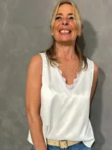 Musculosa blanca de satén con escote en V y detalle de encaje en los bordes.
