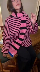 Bufanda de punto de gran tamaño, con diseño de rayas horizontales en azul y negro, y detalles en amarillo en los extremos.