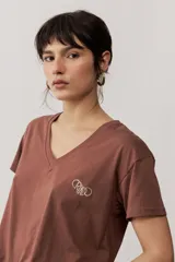 Remera de manga corta color negro, de corte clásico y escote en V, con sutil detalle bordado en el pecho.