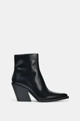 Botín negro de estilo cowboy con caña baja, acabado en punta y tacón curvo en bloque. Cuenta con cierre mediante cremallera lateral.