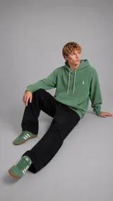 Hoodie de tejido waffle color verde, con capucha, cordones ajustables en color crudo y bolsillo frontal tipo canguro. Presenta un pequeño bordado en el pecho.