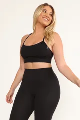 Top deportivo negro con tirantes finos y almohadillas removibles.