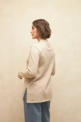 Polera negra de jacquard con cuello alto y aberturas en los laterales y en las mangas.