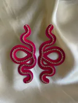 Aros colgantes con forma de serpiente blanca delineada con strass plateado.