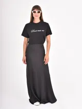 Falda larga de satén color negro, con corte al bies y caída fluida.