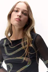 Remera negra de mangas largas transparentes, con apliques de brillos formando ondulaciones.