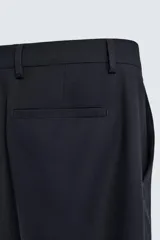 Pantalón de corte recto confeccionado en tejido con lana, color beige. Presenta bolsillos frontales, bolsillos traseros de vivo y cierre frontal con cremallera y botón.