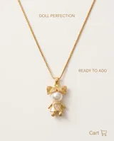 Collar de bronce con cadena fina y dije en forma de silueta de niña con perla sintética en el centro y pequeños cristales incrustados en la zona inferior.
