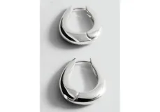 Aros tipo argolla de diseño minimalista y forma orgánica, con acabado metálico plateado.