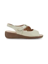 Sandalia de cuero color crema, con puntera descubierta, tira ancha sobre el empeine con ajuste de velcro, talón descubierto con tira ajustable y suela marrón de goma.