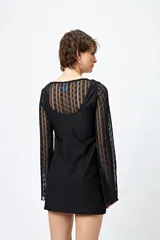 Vestido mini negro de líneas limpias y escote redondeado, con mangas largas de encaje.