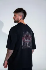 Remera oversize de algodón elastizado en color negro, con diseño gráfico estampado en la espalda que representa un arco gótico con detalles en rojo y texto.