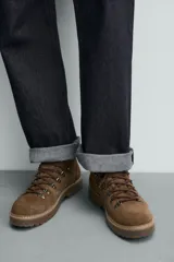 Bota de caña baja con acabado en serraje, horma redonda y suela track con volumen.