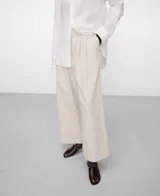 Pantalón ancho de lino y algodón color beige, con cintura elástica en la espalda, doble pinza en el delantero y bolsillos laterales.