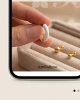 Aros tipo argolla pequeña de acero dorado con recubrimiento esmaltado en color blanco.