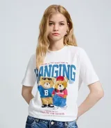 Remera de algodón color blanco, con cuello redondo y mangas cortas. Presenta un estampado frontal de dos ositos con vestimenta urbana y tipografía en tonos azules y rojos.