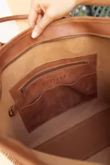 Bolso tipo tote de cuero color marrón con textura tipo cocodrilo, doble asa de hombro y cierre superior con cremallera.