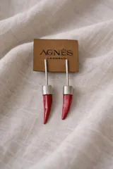Aros colgantes con forma de cuerno rojo y detalles plateados.