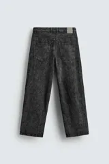 Pantalón de corte baggy fit confeccionado en tejido de algodón con textura y efecto lavado. Presenta diseño de cinco bolsillos, cierre frontal con cremallera y botón.