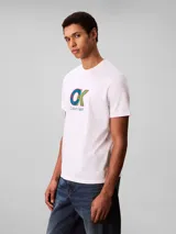 Remera de cuello redondo y manga corta, confeccionada en algodón regenerativo. Presenta un estampado gráfico frontal con el monograma de la marca en colores azul, verde y rojo, acompañado por el logo de Calvin Klein debajo.