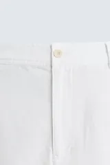 Bermuda azul marino de corte regular fit, confeccionada en tejido de algodón y lino. Cuenta con bolsillos frontales y traseros, cierre frontal con cremallera y botón.