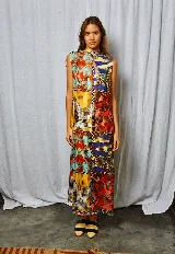 Vestido largo con estampado multicolor, cuello alto abotonado en la parte posterior y tajo lateral.