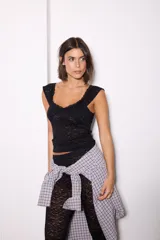 Pantalón de encaje negro con diseño ajustado en la parte superior y corte acampanado en el ruedo.