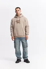 Canguro oversize de algodón con capucha y cordones ajustables. Presenta un diseño de estampa frontal con la frase 'GREAT TIMES' en relieve y bolsillo frontal tipo canguro.