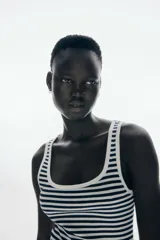 Vestido largo sin mangas, de corte ajustado, con escote redondo ribeteado en blanco y estampado de rayas horizontales blancas y negras.