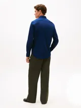 Camisa azul marino de manga larga confeccionada en tejido twill, con cuello flexible y cierre frontal de botones.
