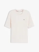 Sweater de punto trenzado fino de color blanco, confeccionado en puro algodón, con cuello redondo y mangas cortas. Presenta un pequeño logo bordado en el pecho.
