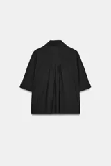 Camisa de cuello solapa y escote pico, color verde militar, con manga corta con trabilla y botón, y cierre frontal con botones.