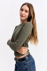 Remera de manga larga con cuello redondo y ajuste al cuerpo, confeccionada en tejido de algodón con textura acanalada.