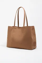 Bolso shopper de gran capacidad confeccionado en nylon color marrón, con estructura blanda, doble asa de mano y logo metálico de la marca en la parte frontal. Incluye cierre con mosquetón y bolsillo interior.