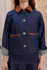 Sobrecamisa de jean liviano con cuello de cuero marrón, corte recto y bolsillos delanteros con ribete de cuero.