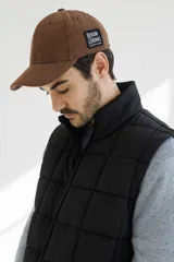 Chaleco acolchado verde militar con cierre frontal y bolsillos laterales.