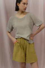 Short blanco de calce relajado con cintura elástica y lazo regulable. Presenta bolsillos amplios con ribete interior de color naranja neón.