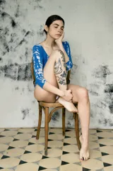 Bodysuit de manga larga con estampado tie-dye en tonos azul y blanco, de corte ajustado.