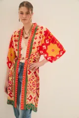 Kimono largo de viscosa con estampado multicolor de estilo étnico. Presenta bordes con detalles geométricos en contraste, mangas anchas y lazo ajustable en la cintura.