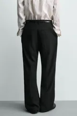 Pantalón de traje con corte relaxed fit, confeccionado en una mezcla de viscosa y lino. Presenta bolsillos laterales delanteros, bolsillos traseros de vivo y cierre frontal con cremallera y gancho oculto.