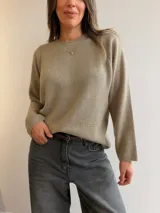 Sweater de punto de corte holgado y diseño minimalista, con cuello redondo y mangas largas. Presenta una textura suave y un largo que llega por debajo de la cadera.