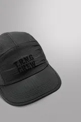 Gorra deportiva de estilo técnico confeccionada en tejido ripstop ligero, con estructura de cinco paneles y visera curva. Presenta el logo bordado en el panel frontal y ojales de ventilación laterales.