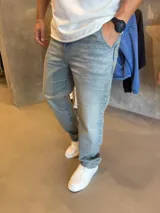Pantalón jean de corte recto y tiro medio, en color celeste claro con efecto desteñido y lavado ácido.