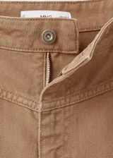 Pantalón jeans estilo wide leg de tiro medio color marrón claro, con diseño suelto, trabillas para cinto, cinco bolsillos y detalles de costuras en la cadera.