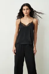 Blusa de tirantes finos en color negro, confeccionada en satén con sutiles brillos, destacando por un delicado detalle de encaje en el escote en V.