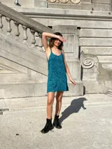 Vestido corto de tirantes finos, confeccionado en tejido de viscosa con lurex brillante en color azul oscuro. Presenta un corte recto y sencillo, ideal para eventos nocturnos.