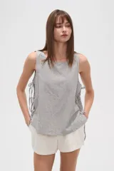 Blusa de viscosa con estampado de rayas verticales, cuello redondo y diseño holgado. Presenta detalles de cordones laterales ajustables.